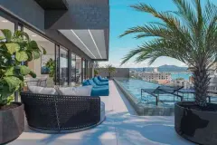 Terraço rooftop com sofá, pufes azuis e piscina infinity com vista para a cidade e o mar — Saint Zambelli em Ingleses, Florianópolis
