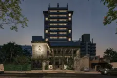 Fachada do edifício à noite com torre de 10 andares iluminada e logotipo Saint Zambelli na entrada — Saint Zambelli em Ingleses, Florianópolis