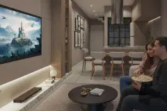 Sala de estar com casal assistindo TV com pipoca, mesa de centro redonda e cozinha ao fundo — Saint Zambelli em Ingleses, Florianópolis