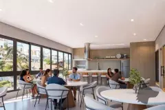 Salão de festas com grupos sentados às mesas, bancada de cozinha e janelas amplas — Saint Zambelli em Ingleses, Florianópolis
