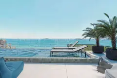Deck da piscina com espreguiçadeiras, palmeira, vista para o mar com ilhas e morros ao fundo — Saint Zambelli em Ingleses, Florianópolis
