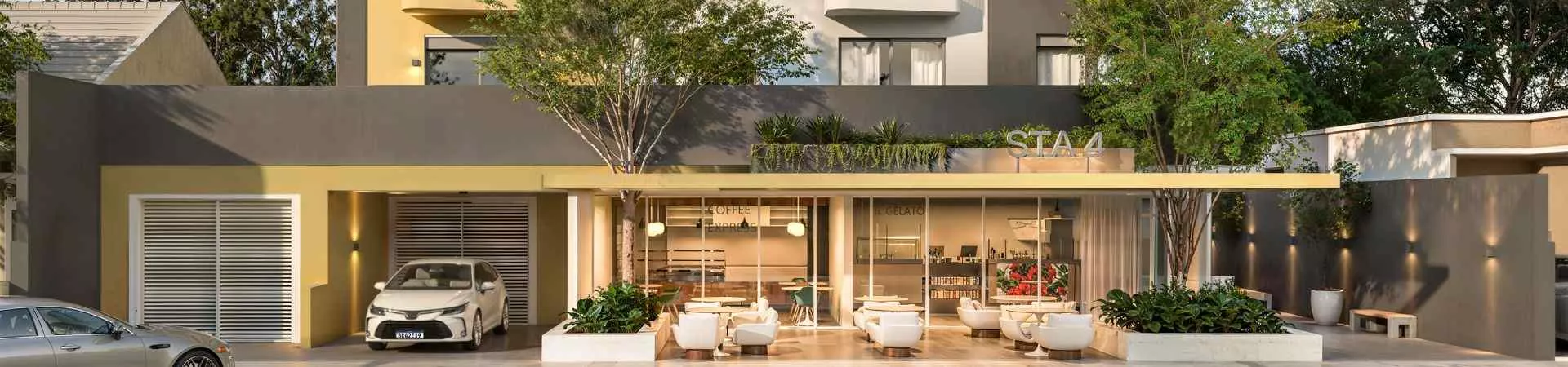 Fachada panorâmica do STA4 com térreo aberto, cafeteria, sorveteria e espaço de convivência com sofás externos — Santa 4 em Santa Mônica, Florianópolis