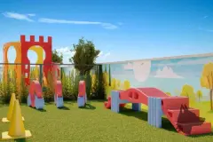 Playground externo com obstáculos infantis coloridos em gramado com painel temático decorativo — Seleto Carlessi em Trindade, Florianópolis