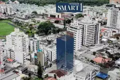 Vista aérea do bairro Trindade com logo Smart 1 Studios sobreposto e edifício em destaque — Smart 1 Trindade em Trindade, Florianópolis