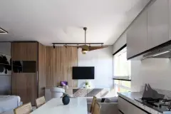 Sala de estar integrada à cozinha com painel de ripas de madeira, TV, mesa de jantar e janelão — Solis em Ingleses, Florianópolis