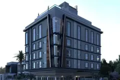 Fachada do edifício ao entardecer em perspectiva diagonal com acabamento cinza e elemento envidraçado — Solis em Ingleses, Florianópolis