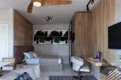 Suíte master com cama de casal, painel de madeira, TV, mesa de trabalho e sofá integrados — Solis em Ingleses, Florianópolis