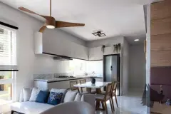 Sala de estar integrada à cozinha com sofá, mesa de jantar, ventilador de teto e armários brancos — Solis em Ingleses, Florianópolis