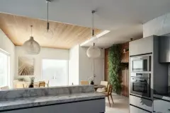 Cozinha com ilha de mármore, luminárias pendentes variadas, jardim vertical e fornos embutidos — Solis em Ingleses, Florianópolis