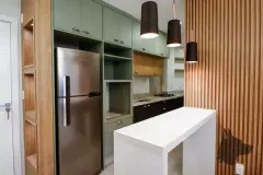 Cozinha do apartamento decorado com armários verdes, geladeira inox, bancada branca e luminária pendente — Summer Park Residence - Fase 2 em Vargem do Bom Jesus, Florianópolis