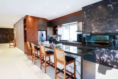 Espaço gourmet com balcão de granito escuro, banquetas altas e integração com salão de festas — Summer Park Residence - Fase 2 em Vargem do Bom Jesus, Florianópolis