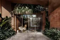 Garden interno com parede de azulejos terracota, sofá bege, porta de vidro e plantas tropicais — Terracota em Morro das Pedras, Florianópolis