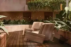 Varanda com duas poltronas de madeira, deck ripado e jardim com orquídeas e folhagens — Terracota em Morro das Pedras, Florianópolis
