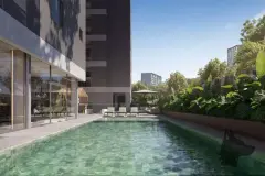Piscina linear com espreguiçadeiras verdes, guarda-sol e jardim tropical exuberante — Torres do Porto em Estreito, Florianópolis