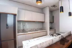 Sala de estar com sofá branco, mesa de jantar de madeira, TV e cozinha integrada — Tramonto em Ingleses, Florianópolis