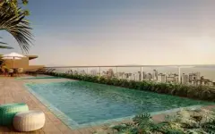 Piscina do rooftop com deck de madeira e vista panorâmica para o centro de Florianópolis ao entardecer — Unity em Estreito, Florianópolis