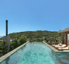 Piscina de borda com deck de madeira, espreguiçadeiras e morros verdes ao fundo — Upside Beach em Ponta das Canas, Florianópolis