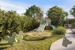 Playground infantil com escorregador, balanço e gangorra em jardim com árvores tropicais — Upside Beach em Ponta das Canas, Florianópolis
