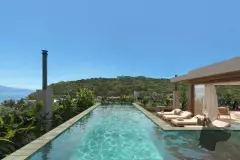 Piscina infinity no rooftop com espreguiçadeiras e vista panorâmica para morro e vegetação — Upside Beach em Ponta das Canas, Florianópolis