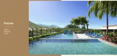 Piscina com deck de pedra, espreguiçadeiras azuis, palmeiras e vista panorâmica para as montanhas do Campeche — Vergê en Campeche, Florianópolis