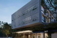 Detalhe da fachada do edifício Verset à noite, bloco de treliça sobressalente iluminado e lojas no térreo — Verset em Campeche, Florianópolis