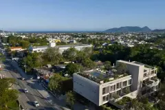 Vista aérea do edifício Verset no Campeche com o bairro ao redor, mar e o Morro do Lampião ao fundo — Verset em Campeche, Florianópolis
