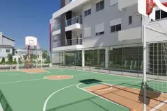 Quadra poliesportiva verde com tabela de basquete e trave de futebol, academia com parede de vidro ao fundo — Viel Spaβ em Ingleses, Florianópolis