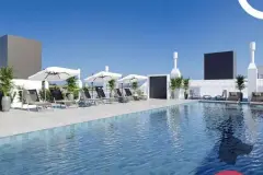 Piscina do rooftop com espreguiçadeiras, guarda-sóis brancos e painel de LED ao fundo — Viel Spaβ em Ingleses, Florianópolis