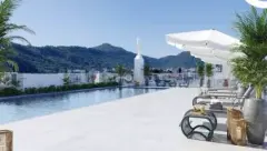 Piscina no rooftop com espreguiçadeiras, guarda-sol branco e vista para o morro, ângulo alternativo — Viel Spaβ em Ingleses, Florianópolis