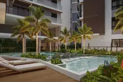 Área da piscina à noite com palmeiras iluminadas, espreguiçadeiras e deck de madeira ao redor — Villa Maggiore em João Paulo, Florianópolis
