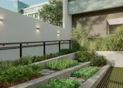 Horta vertical com canteiros escalonados de concreto plantados de ervas e hortaliças, arandelas na parede ao fundo — Viva Balneário Estreito em Balneário, Florianópolis