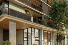 Fachada do edifício em close com lojas Lavender Jewelry e Estelle no térreo, marquise de madeira e varandas — Viva Balneário Estreito em Balneário, Florianópolis