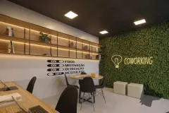 Coworking com bancada de madeira, parede com jardim vertical e letreiro neon COWORKING — VYU One em Coqueiros, Florianópolis