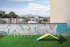 Pet place no rooftop com grama sintética, obstáculos para cães, mural com animais e ducha pet — VYU One em Coqueiros, Florianópolis