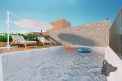Piscina no rooftop com boias coloridas, espreguiçadeiras e guarda-sol junto a parede de pedra — VYU Pulse em Coqueiros, Florianópolis