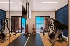 Academia com bicicletas ergométricas, aparelhos de musculação, TV e parede azul — VYU Pulse em Coqueiros, Florianópolis