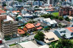 Vista aérea do bairro Coqueiros com o edifício VYU visível entre as construções — VYU Pulse em Coqueiros, Florianópolis