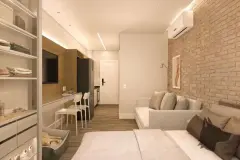 Studio com sofá, painel de TV, cozinha integrada, parede de tijolinho e closet lateral — VYU Pulse em Coqueiros, Florianópolis