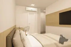 Dormitório compacto com cama, ar-condicionado, painel de TV em madeira e escrivaninha integrada — VYU Pulse em Coqueiros, Florianópolis