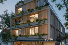 Fachada do edifício Yuná à noite com ripas de madeira, varandas com jardins suspensos e letreiro iluminado — Yuná Blue View em Campeche, Florianópolis
