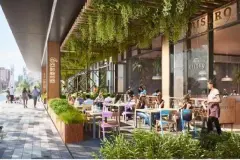 Bistrô externo com mesas coloridas, clientes, vegetação suspensa e fachada de vidro — Yuná Blue View em Campeche, Florianópolis
