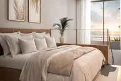 Quarto de casal com cabeceira em madeira, roupa bege e janela com pôr do sol sobre o mar em ângulo frontal — Yuná Blue View em Campeche, Florianópolis