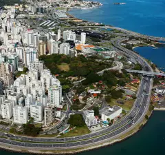 Vista aérea do Centro de Florianópolis mostrando orla, avenida Beira-Mar, edificações e baía ao fundo — Zenn Living Residence em Centro, Florianópolis
